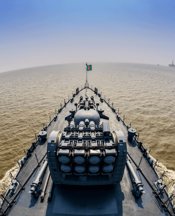 A navy ship is sailing on the river.